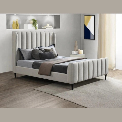 A modern bedroom with the Isobella Bedframe in light gray and high headboard, layered gray and brown bedding, beige rug, neutral walls, decorative shelf, abstract wall art, and sheer beige curtains.