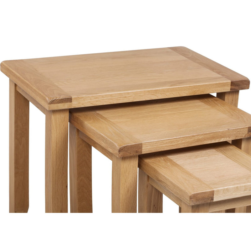 Furniture photo of three light-colored, square-legged wooden side tables nested together.