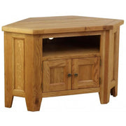 The Saoirse Corner TV Unit is a handmade solid oak stand with a pentagonal top, open shelf, and two cabinet doors with metal knobs. It features simple panel detailing and a light wood finish.