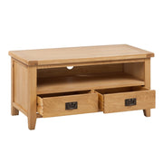 The Saoirse TV Unit is a handmade solid oak stand with an open shelf, two lower drawers with metal handles, shown against a plain white background.
