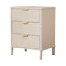 The Parson Locker is a beige 3 drawer nightstand with gold handles and vertical grooves, offering stylish bedroom storage on four short legs.