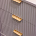 Close-up of the Parson Locker featuring 3 drawers with gray ribbed fronts and gold curved handles. Its vertical grooves and modern angles add a stylish, industrial touch to any locker-inspired space.