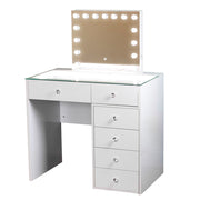 The Erika Hollywood Dressing Table Bluetooth 92cm features a sleek white finish, a glass top, five spacious drawers, and a mirror framed by round LED lights—perfect for creating a glamorous space. The bright, even illumination from the LED-lit mirror ensures flawless makeup application every time.