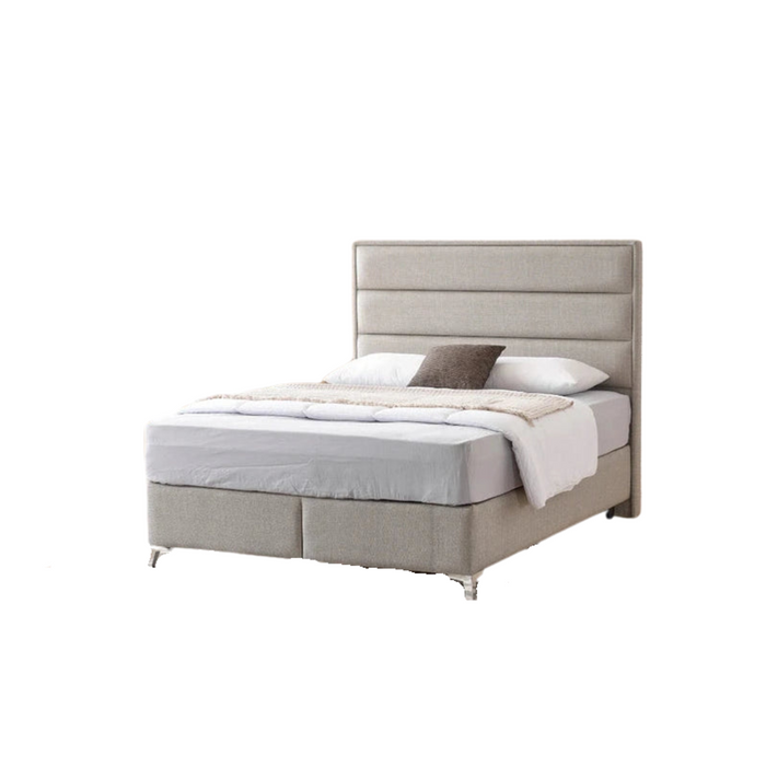 The Iris Storage Bedframe features a tall, horizontal-panel headboard in light gray upholstery, white bedding, a gray pillow, and a beige throw blanket perfect for adding stylish storage to your bedroom.