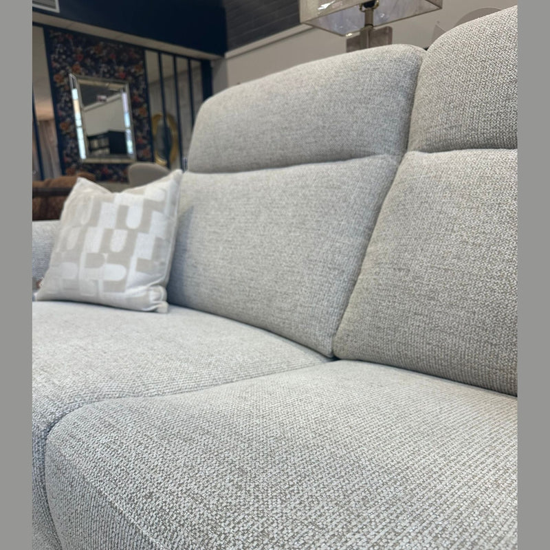 Close-up of the Luna Electric Recliner in light gray, featuring a patterned white pillow on the left side, set in a stylish living room with a lamp and decor visible in the background.