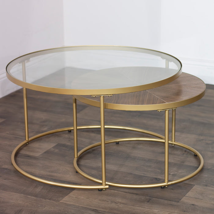 The Andree Coffee Table set includes two modern nesting tables—one with a round glass top, the other slightly smaller with a wooden top—both accented by elegant brass legs and designed to complement any wooden floor.