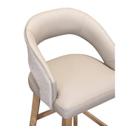 The Willow Dining Chair features a modern design with a light beige padded seat, curved backrest, textured outer fabric, and wooden legs.