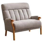 A modern armchair with simple lines on the backrest and light oak wooden legs, upholstered in a grey fabric.