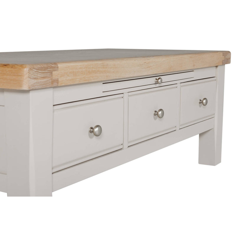 A close-up of the Doune Coffee Table, featuring a light gray finish, natural oak veneer top, three storage drawers with silver knobs.