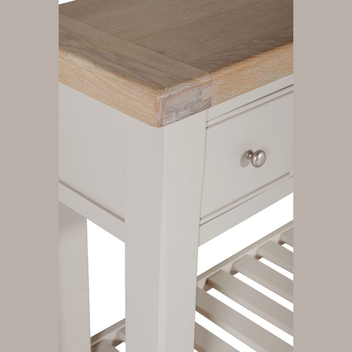 A close-up of the Doune Console Table, featuring a taupe finish, natural wood top, small drawer with round silver knob, and a slatted lower shelf.