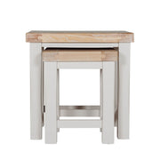 The Doune Nest of Tables features light oak tops and white painted legs, with one table fitting under the other for versatile style and space-saving elegance.