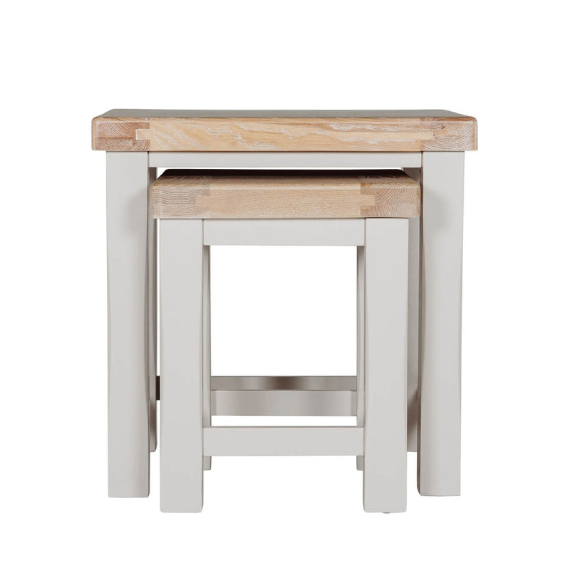 The Doune Nest of Tables features light oak tops and white painted legs, with one table fitting under the other for versatile style and space-saving elegance.