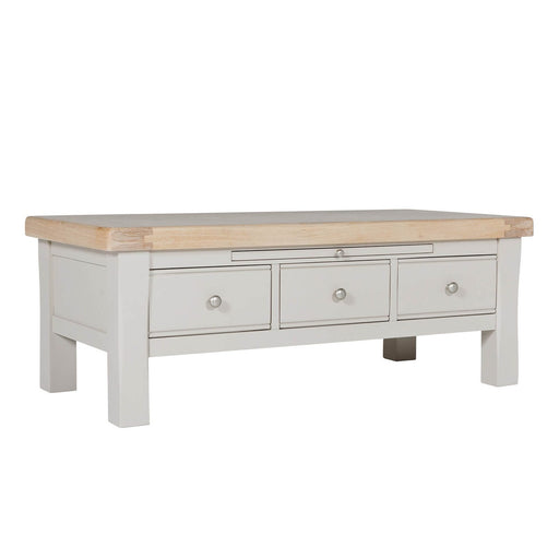 A taupe coffee table with oak veneer top, featuring three small drawers with metal handles.