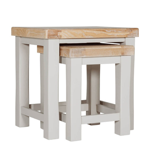 The Doune Nest of Tables features light oak tops and white painted legs, with the smaller table partially tucked under the larger one, all set against a plain white background.