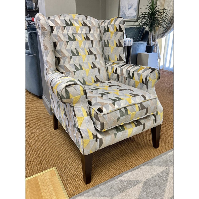 Accent chair with high back and rolled arms, upholstered in a striking yellow and gray triangular print fabric.
