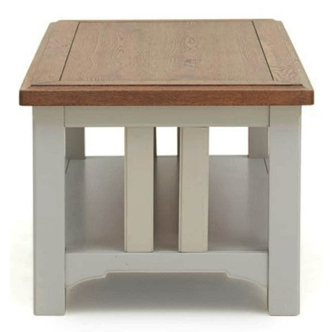 The Eden Coffee Table features a handcrafted solid oak top, soft grey base, and a lower storage shelf. Its simple, modern design offers clean lines and sturdy construction—perfect for any living space.