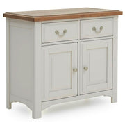 The Eden Small Sideboard features a white wooden frame, solid oak top, two drawers with metal handles, and two cabinet doors with round knobs, all supported by four sturdy legs.