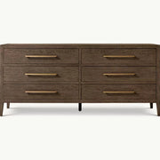 The Hampshire Wide Chest is a modern wooden dresser with a dark wood finish, six drawers featuring long slim gold handles, and short angled legs, perfect for adding style and storage to your bedroom.