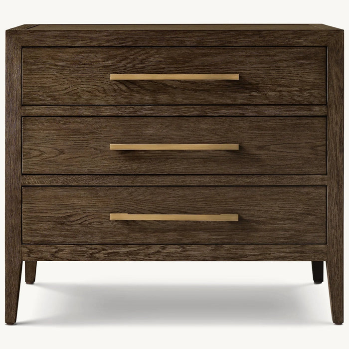 The Hampshire Locker, a dark wood dresser with three drawers, gold horizontal handles, and tapered legs, adds timeless style to any space, displayed here against a plain white background.