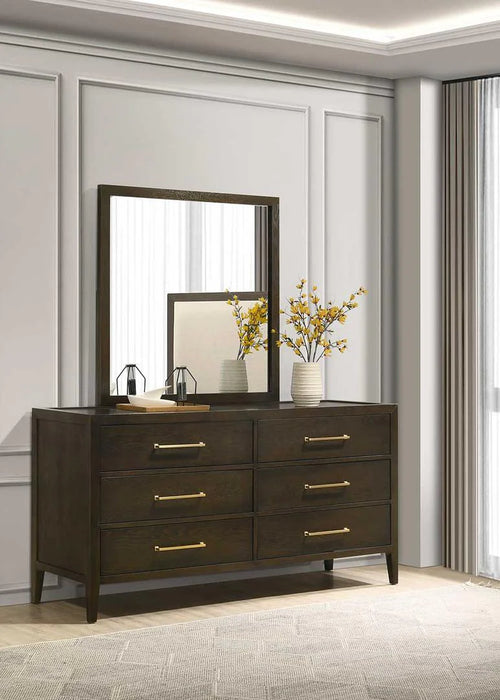 The Hampshire Wide Chest features a mirror and decorative flowers on top, all in a stylish dark wood finish.