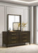 The Hampshire Wide Chest features a mirror and decorative flowers on top, all in a stylish dark wood finish.