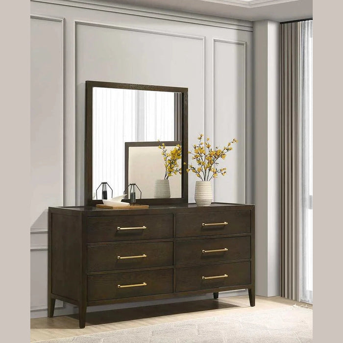 The Hampshire Wide Chest features a mirror and decorative flowers on top, all in a stylish dark wood finish.