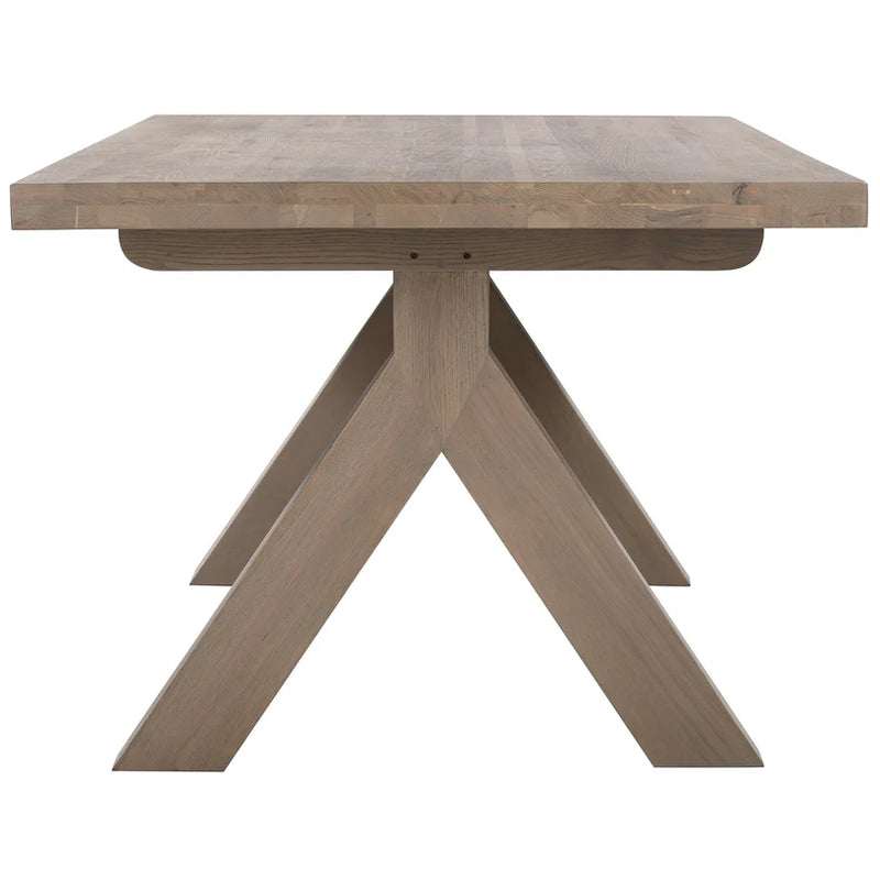 The Marlo Y Leg Table features a thick rectangular top and distinctive crossed-leg base in a light natural wood tone, showcased against a white background.