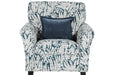 The Pippa Accent Chair features white and dark blue upholstery with a leaf pattern and includes a square dark blue throw pillow centered on the backrest.