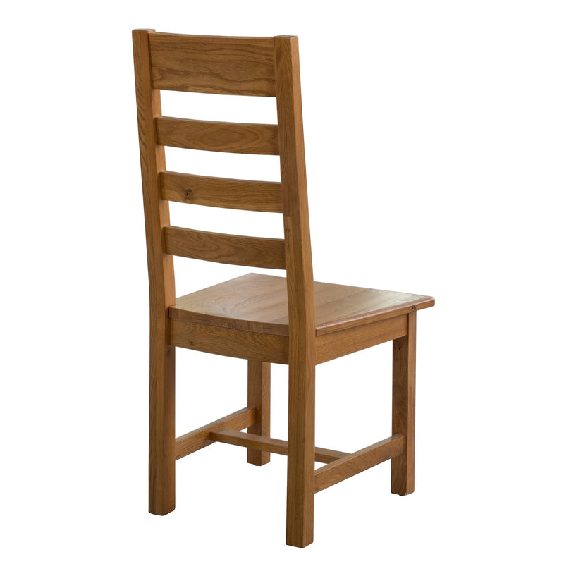 The Saoirse Dining Chair is a premium handmade oak chair featuring a high ladder-style back, flat seat, square legs, and shown angled from behind.
