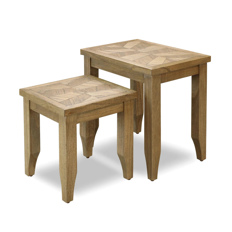 The Solstice Nest features two wooden tables with chevron-patterned tops, the smaller nestling beneath the larger. Both have straight legs and a natural wood finish, ideal for a mid-century modern look.